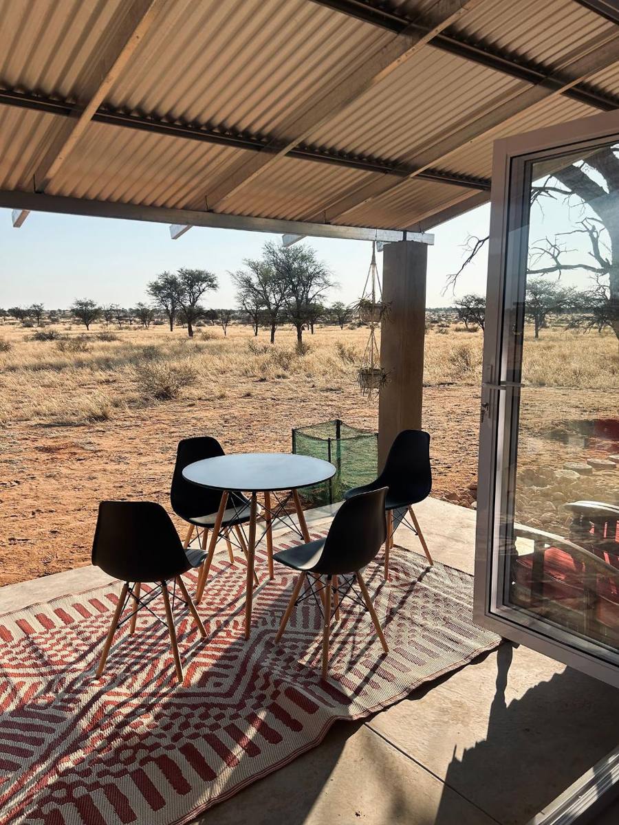Covered stoep with a table and chairs looking out over the farm